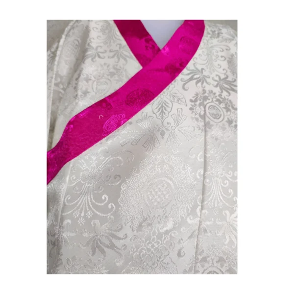 Close-up of hot-pink brocade border on ivory toego kids bakhu