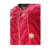 Close-up of maroon velvet blouse showing gold floral embroidery and piping
