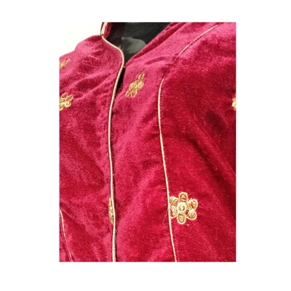 Close-up of maroon velvet blouse showing gold floral embroidery and piping