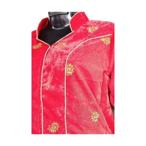 Close-up of red velvet blouse with gold motif and piping detail