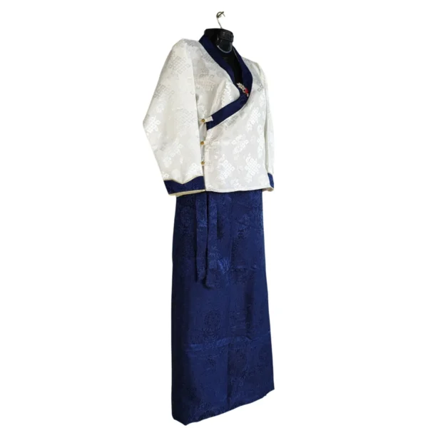Side view of ivory-navy bakhu set showing wrap jacket buttons and tie skirt