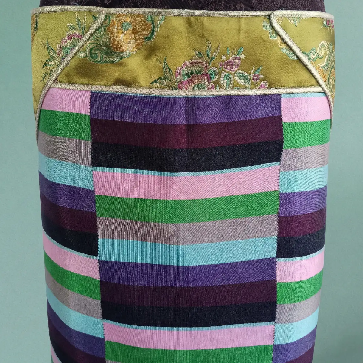 Close-up view of olive and multicolour stripes on Pangden apron