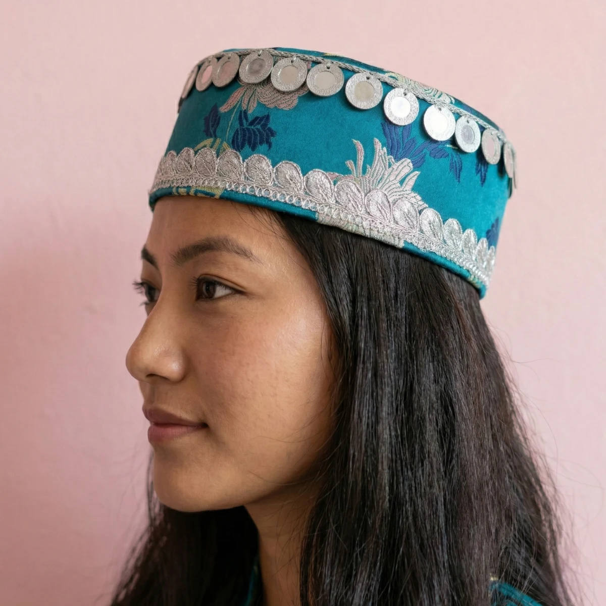 Close-up of silver metallic coin discs and seed bead motis on teal Tamang wedding topi Close-up of silver metallic coin discs and seed bead motis on teal Tamang wedding topi