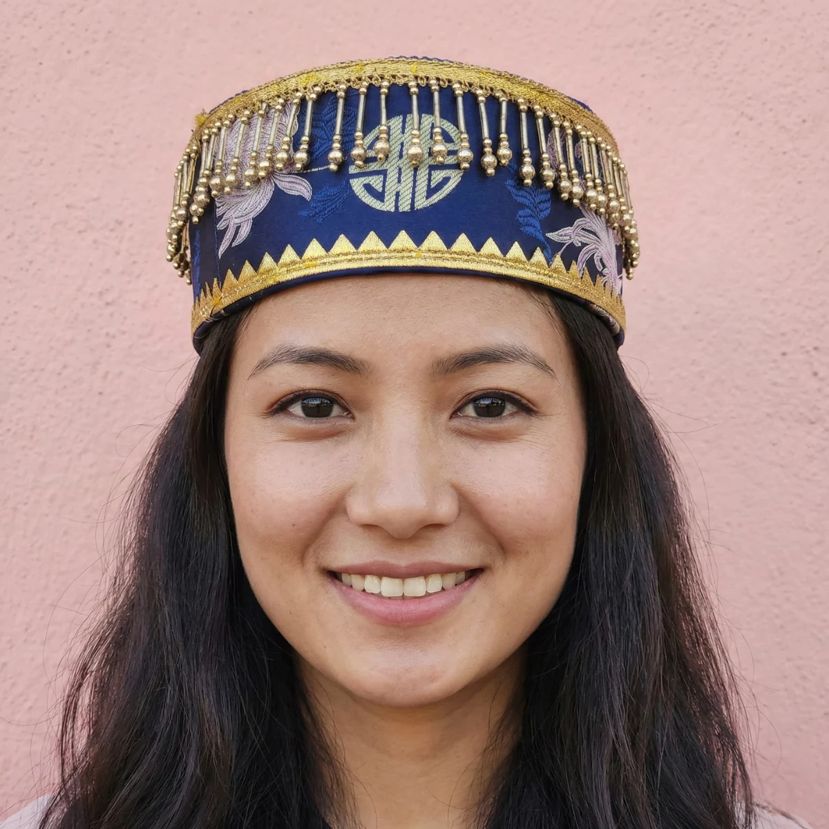 Girl wearing Tamang wedding topi in navy blue Tash Kuchin with gold fringe trim and motis Girl wearing Tamang wedding topi in navy blue Tash Kuchin with gold fringe trim and motis