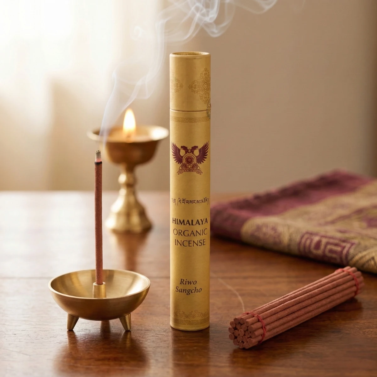 Riwo Sangcho Himalayan organic incense tube — Garuda emblem and Tibetan script, smoking stick in brass tripod holder