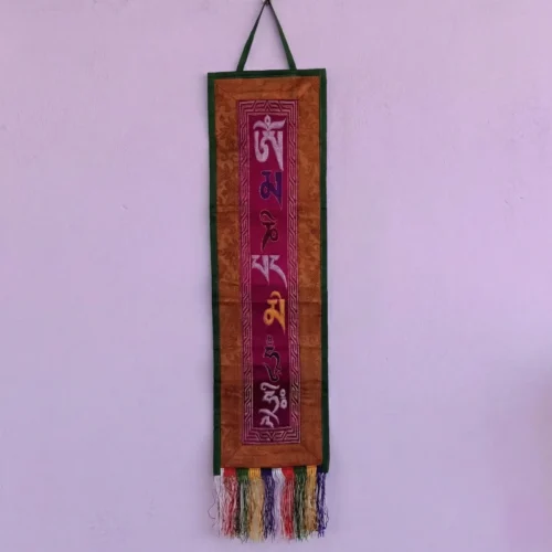 Tibetan mantra wall hanging — deep magenta ground with Om Mani embroidery, bronze jacquard brocade border