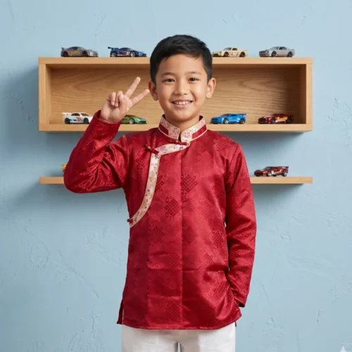 Boy wearing Red Kids Khenja jacquard top with cream Tash Kuchin border peace sign front view