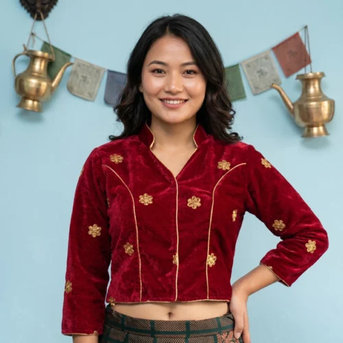 Woman wearing maroon embroidered velvet Mandarin collar blouse front view with gold piping