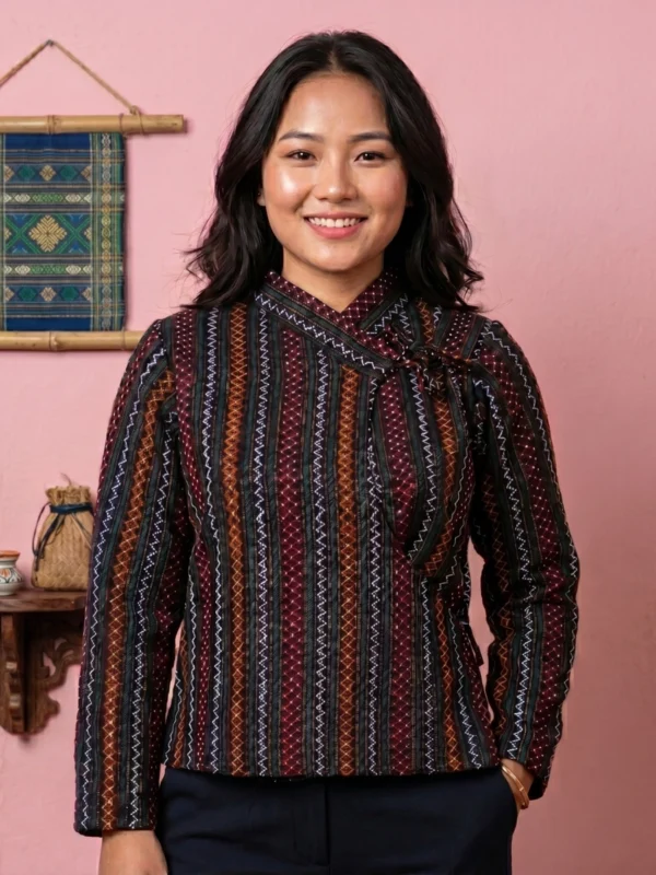 Woman wearing in multi stripe pattern Newari Chaubandi cholo front view with cultural backdrop