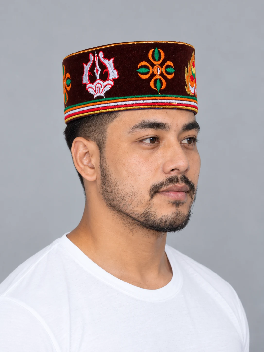 Embroidered Velvet Tamang Topi for Men 3 Man wearing maroon embroidered velvet topi three quarter view 2