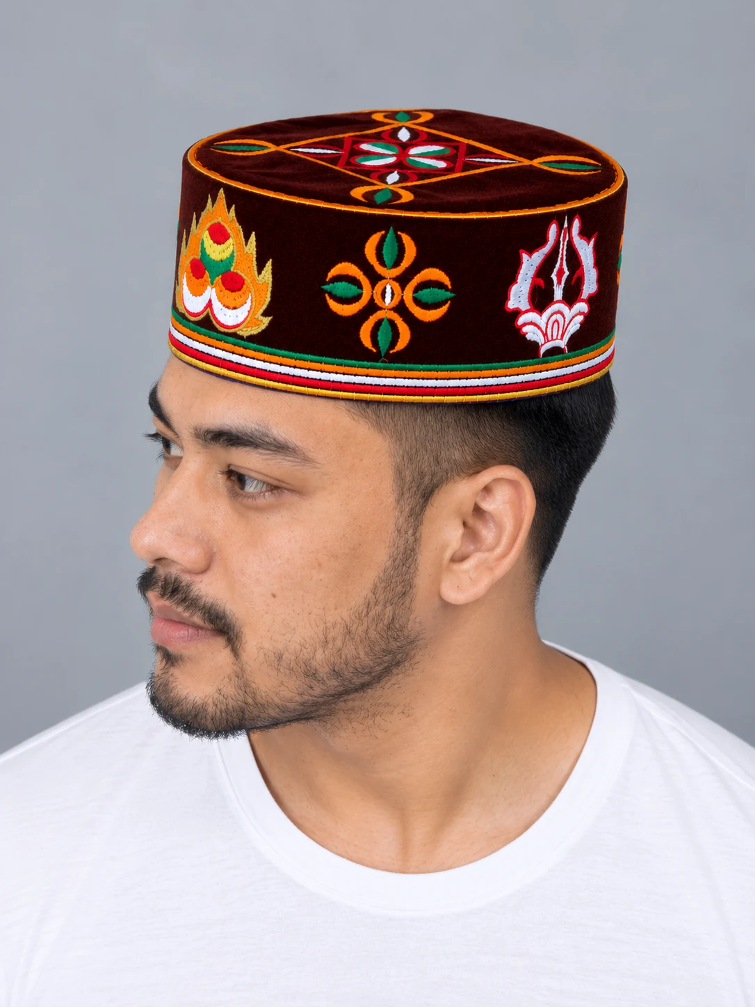 Embroidered Velvet Tamang Topi for Men 2 Man wearing maroon embroidered velvet topi three quarter view