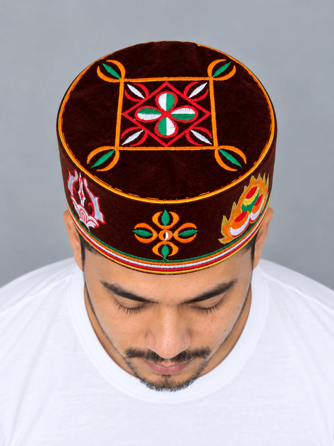 Embroidered Velvet Tamang Topi for Men 5 Man wearing maroon embroidered velvet topi top view