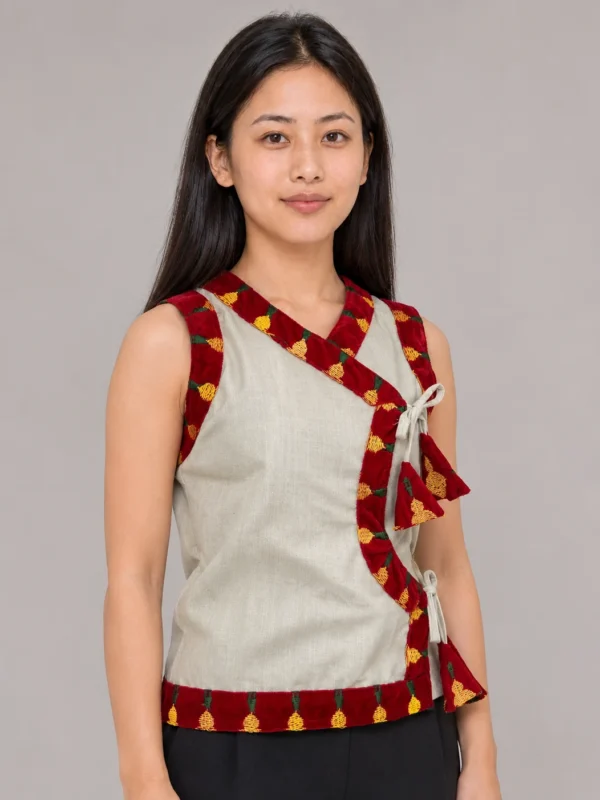 Woman wearing sleeveless rai cholo with embroidered velvet chindu border front view